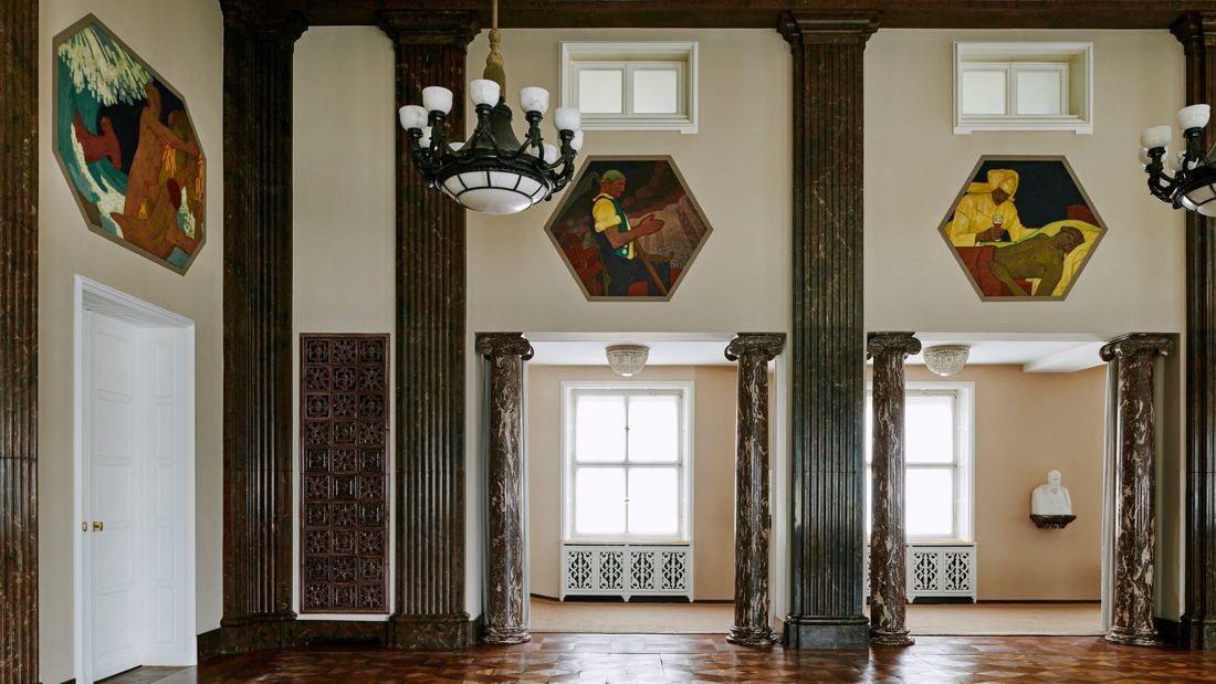 Munich Re: Hall with dark marble pilasters, chandeliers and hexagonal paintings on the walls