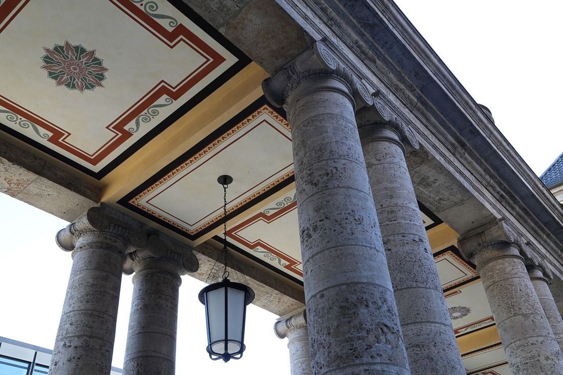 Munich Re: Painted coffered ceiling and lantern under a row of thick stone columns