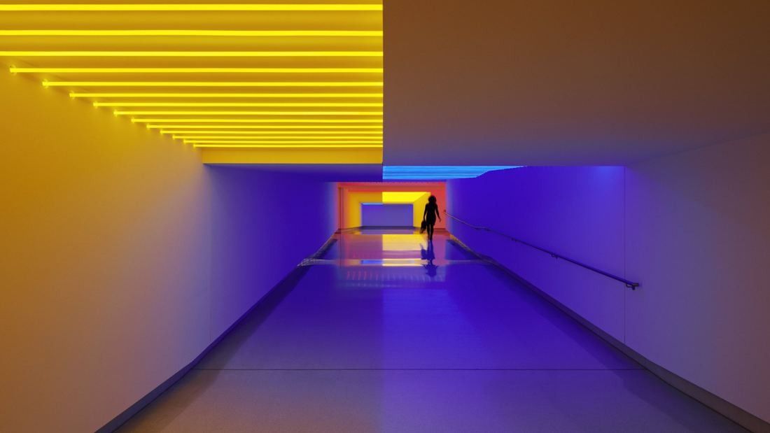Munich Re: Passage lit yellow and blue with a distant silhouette walking through