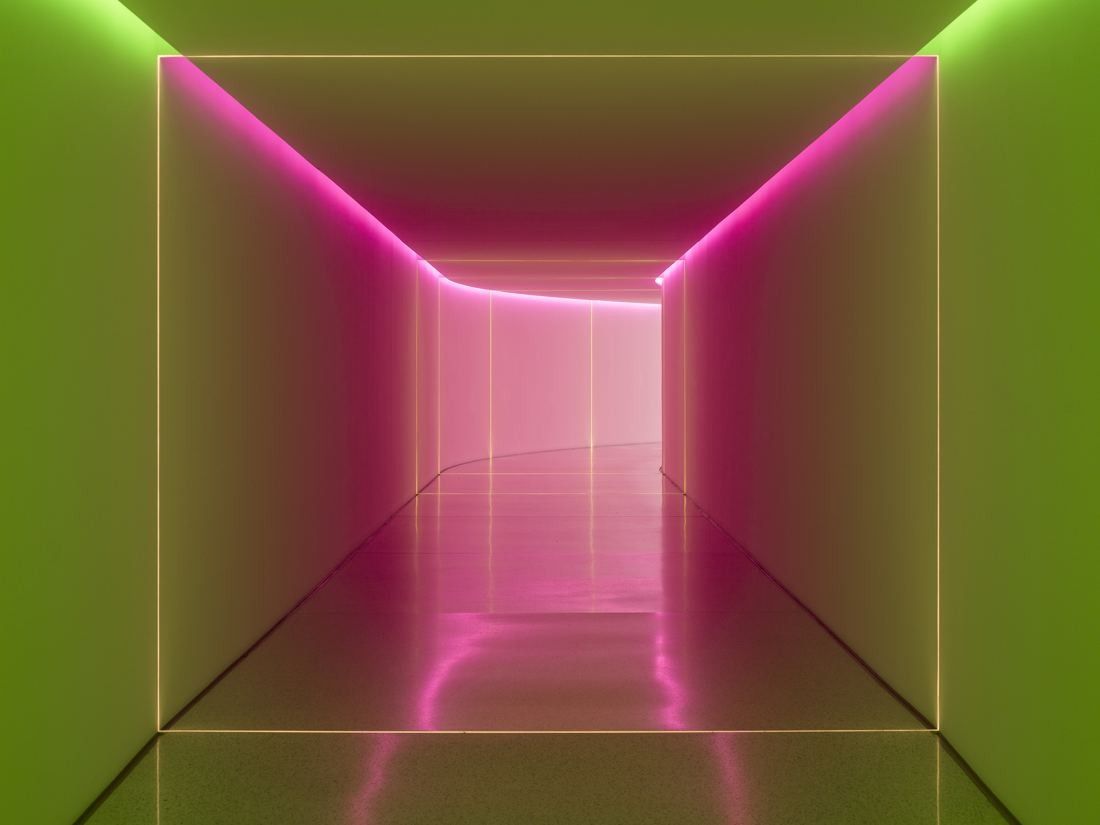 Munich Re: Underground passage glowing pink and green from a light installation