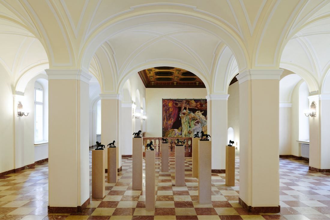 Munich Re: Vaulted hall with checkered floor, sculptures on plinths and a large painted fresco on the end wall