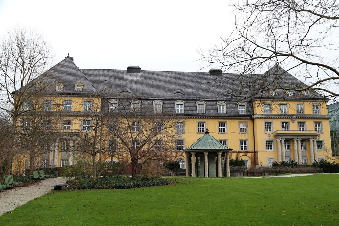 Munich Re: Yellow building with a green-roofed pavilion in front of a lawn