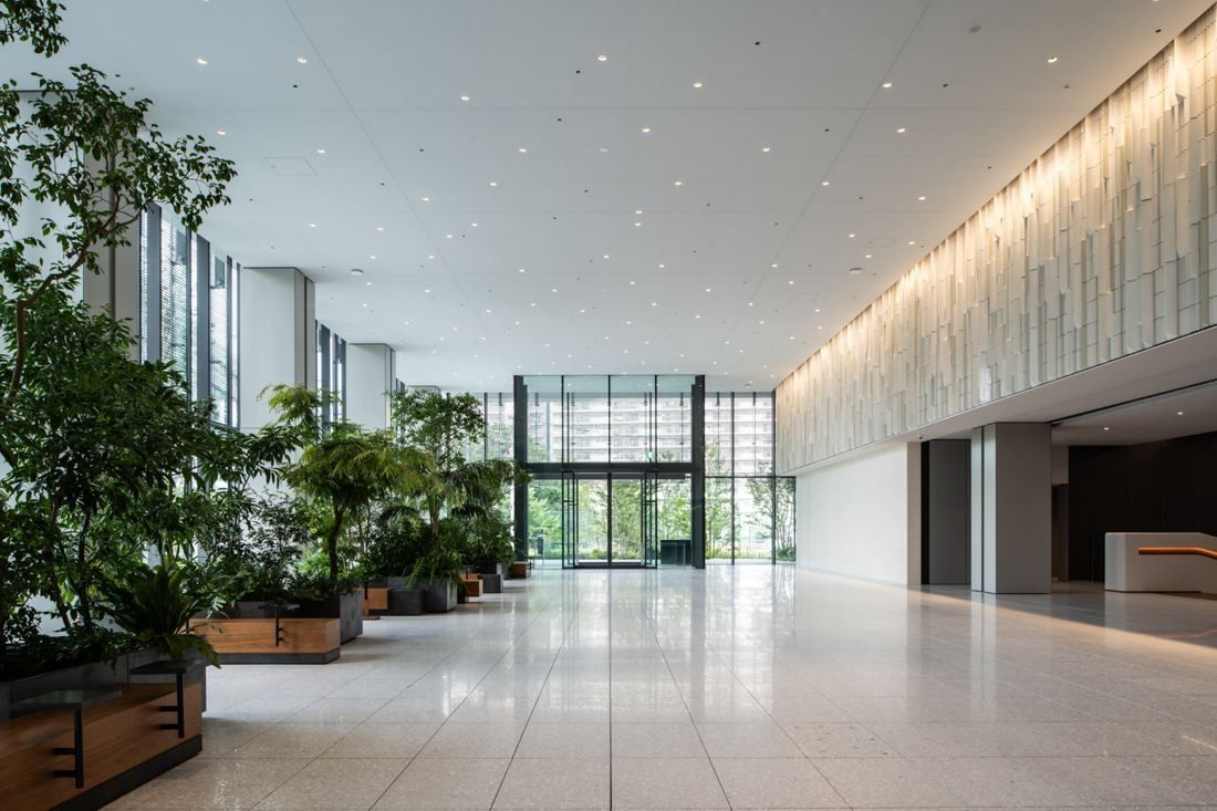 Nikon: Bright, high entrance hall with stone floor, planters and a glass front