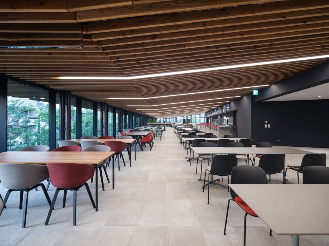Nikon: Dining tables along a glass wall under a slatted ceiling