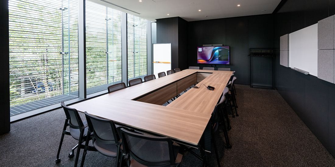 Nikon: Meeting room with a long wooden table and a screen