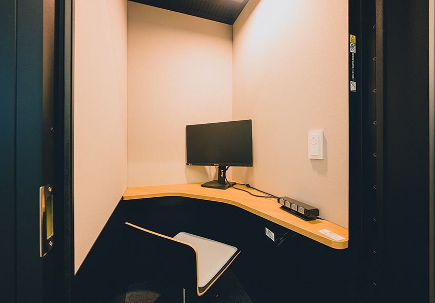 Nikon: Small enclosed booth with a desk, monitor and chair