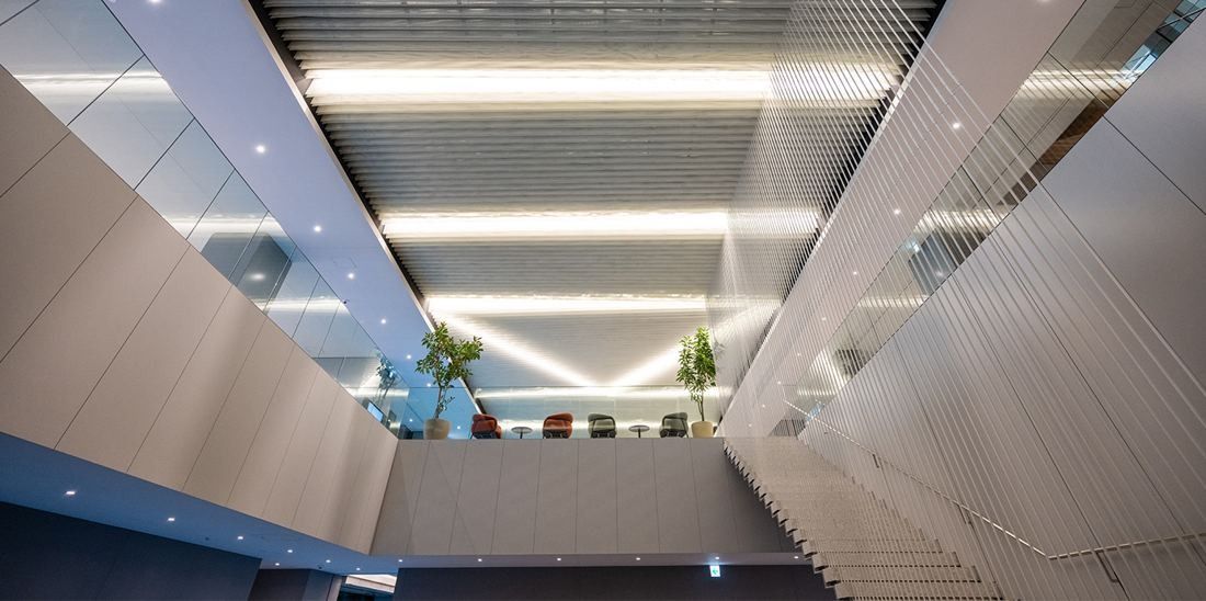 Nikon: Void between floors with angled white walls and ceiling lights