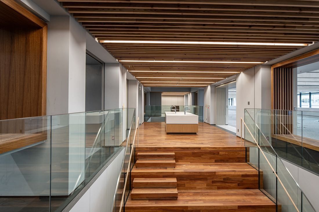 Nikon: Wooden steps between glass balustrades under a slatted ceiling