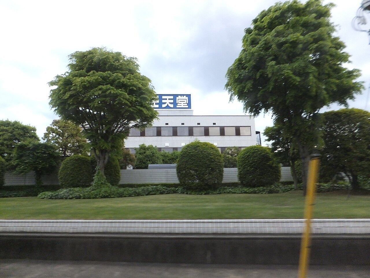 Low factory building behind trees with a Nintendo sign