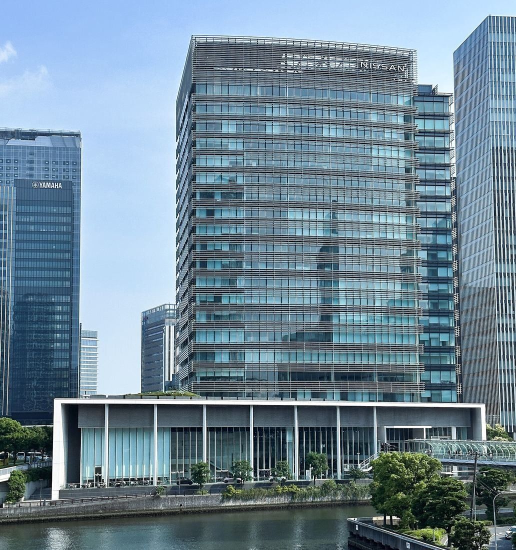 Nissan: Glass tower and its podium seen across a canal