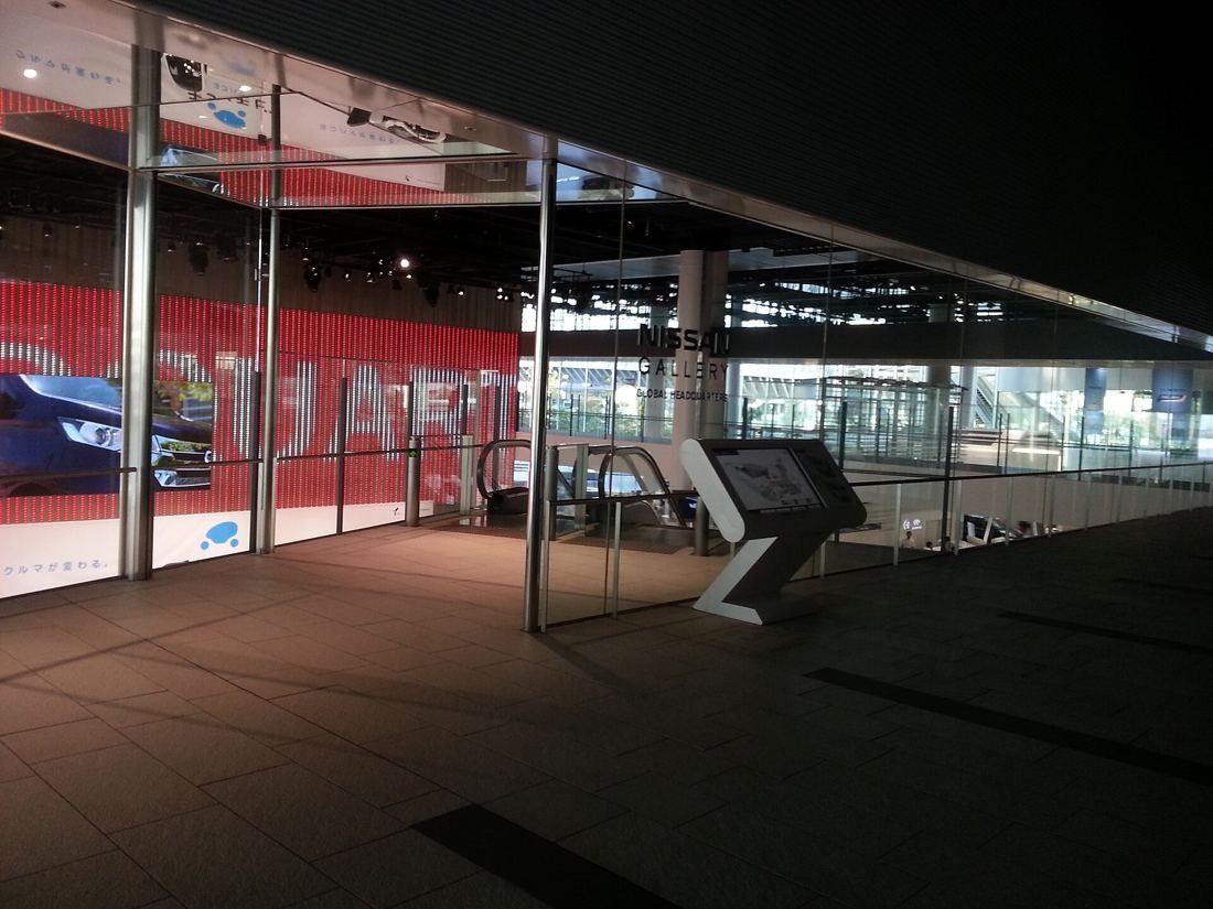 Nissan: Glass-walled entrance lit at night with an information kiosk