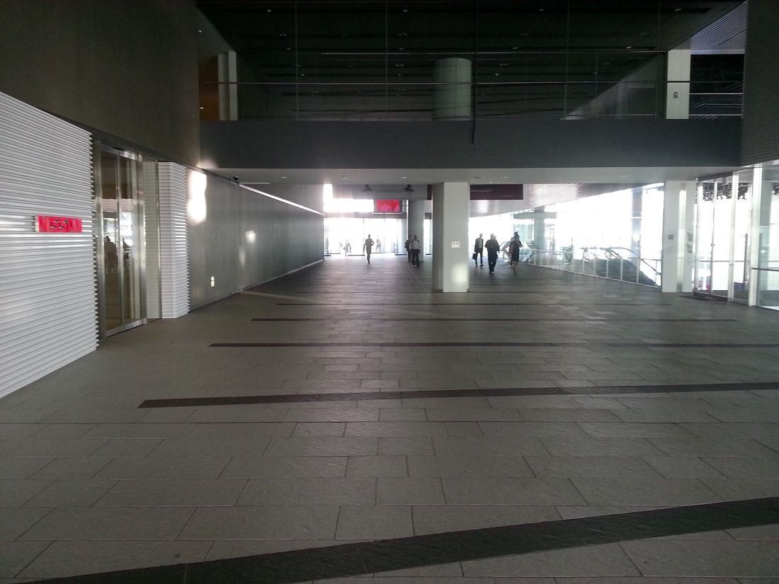 Nissan: Long paved walkway under a high ceiling leading toward bright windows