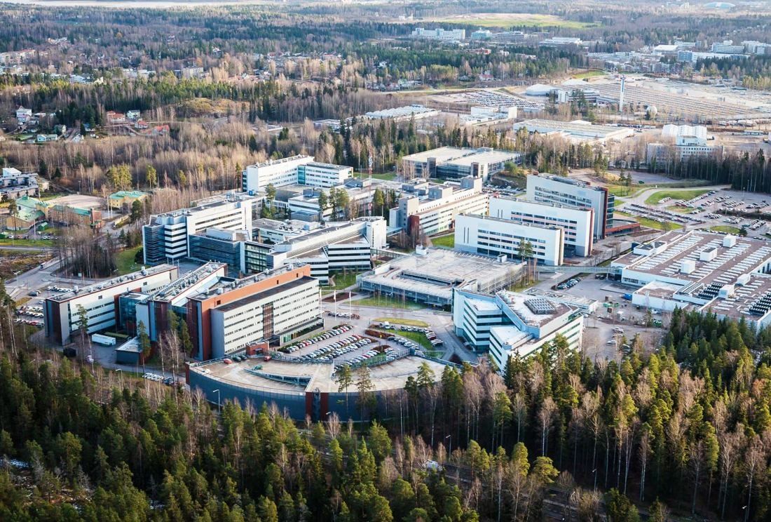 Nokia: Aerial view of a cluster of office buildings in autumn forest under a cloudy sky