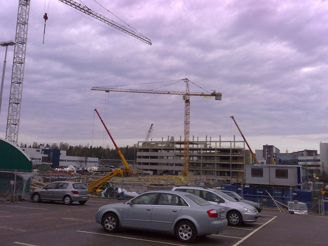 Nokia: Construction site with tower cranes and an unfinished building beyond a car park