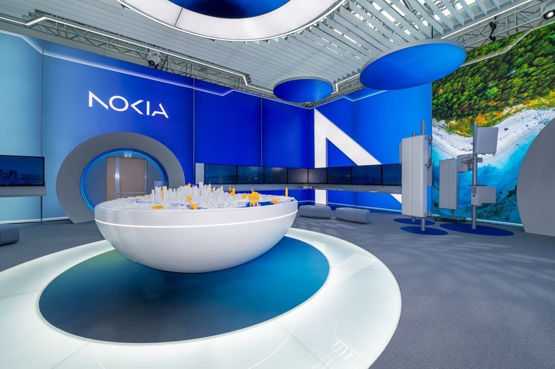 Nokia: Showroom with a large white bowl-shaped table on a lit circular floor, blue walls and round ceiling lights