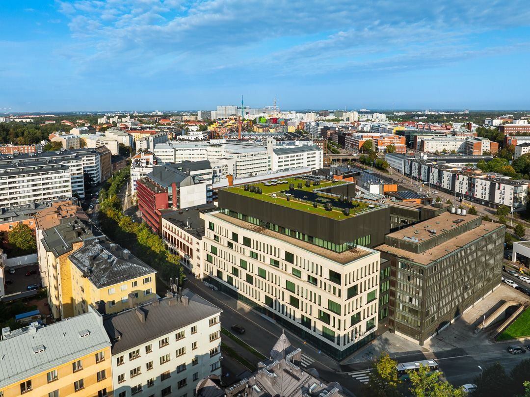 Nordea: Aerial view of the city block with a pale brick building and green roofs among surrounding streets