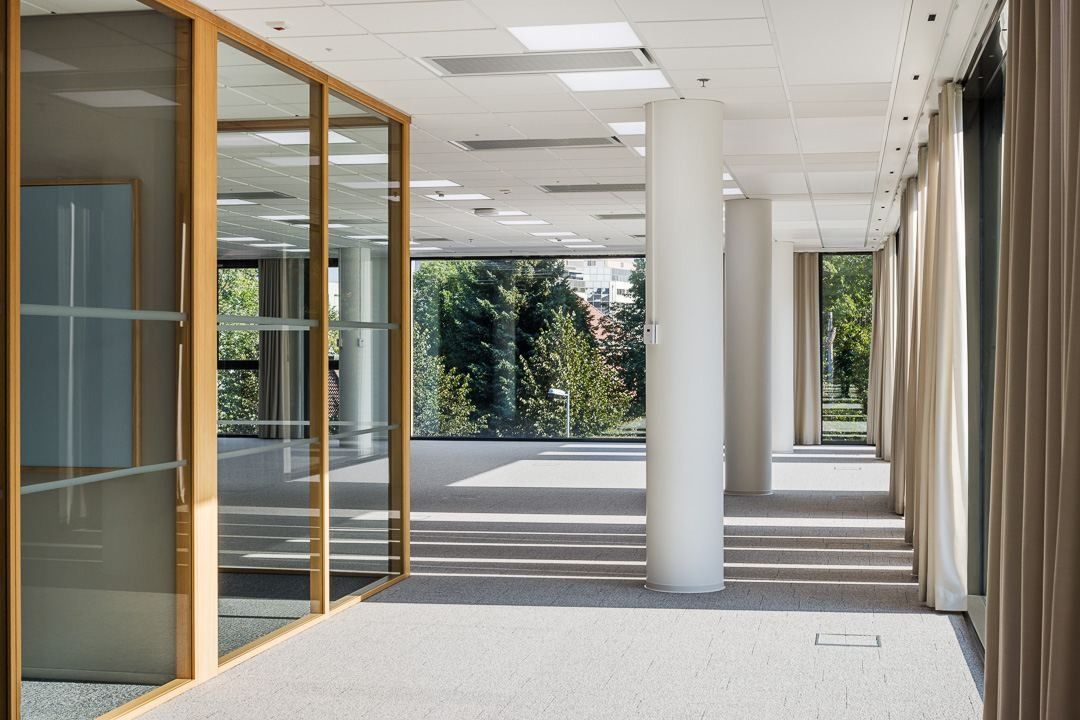 Nordea: Bright empty office floor with wood-framed glass doors and columns
