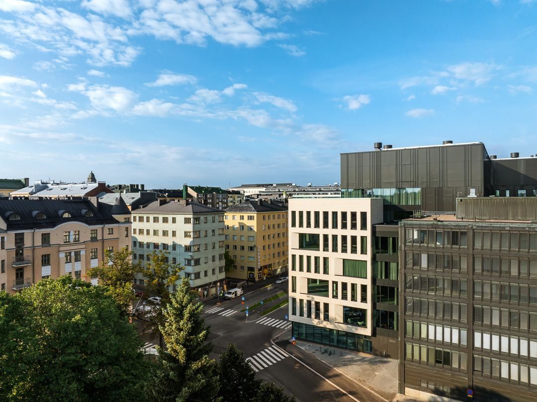 Nordea: Elevated view over the street with the pale brick office building between older apartment blocks