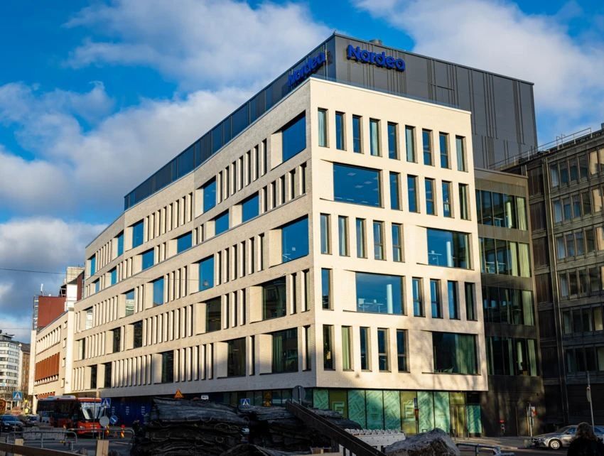 Nordea: Pale office building with the Nordea sign on top, seen across a street