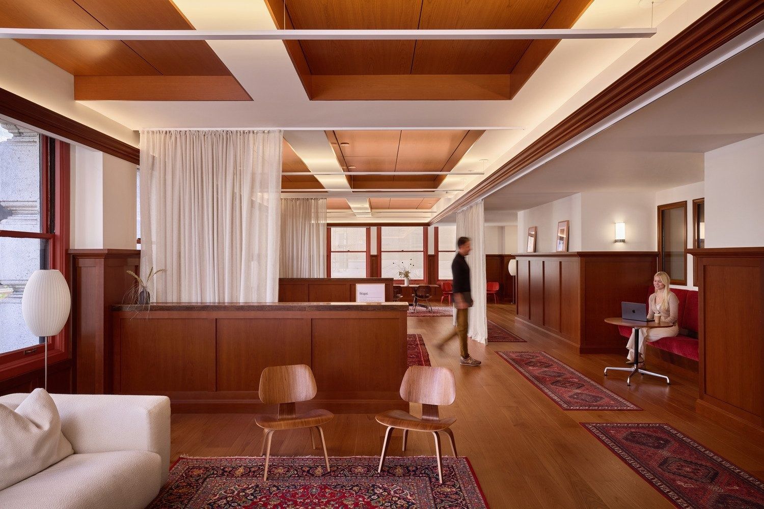 Notion: Lounge with coffered wood ceiling, sheer curtains, Persian rugs, molded wood chairs and a red banquette