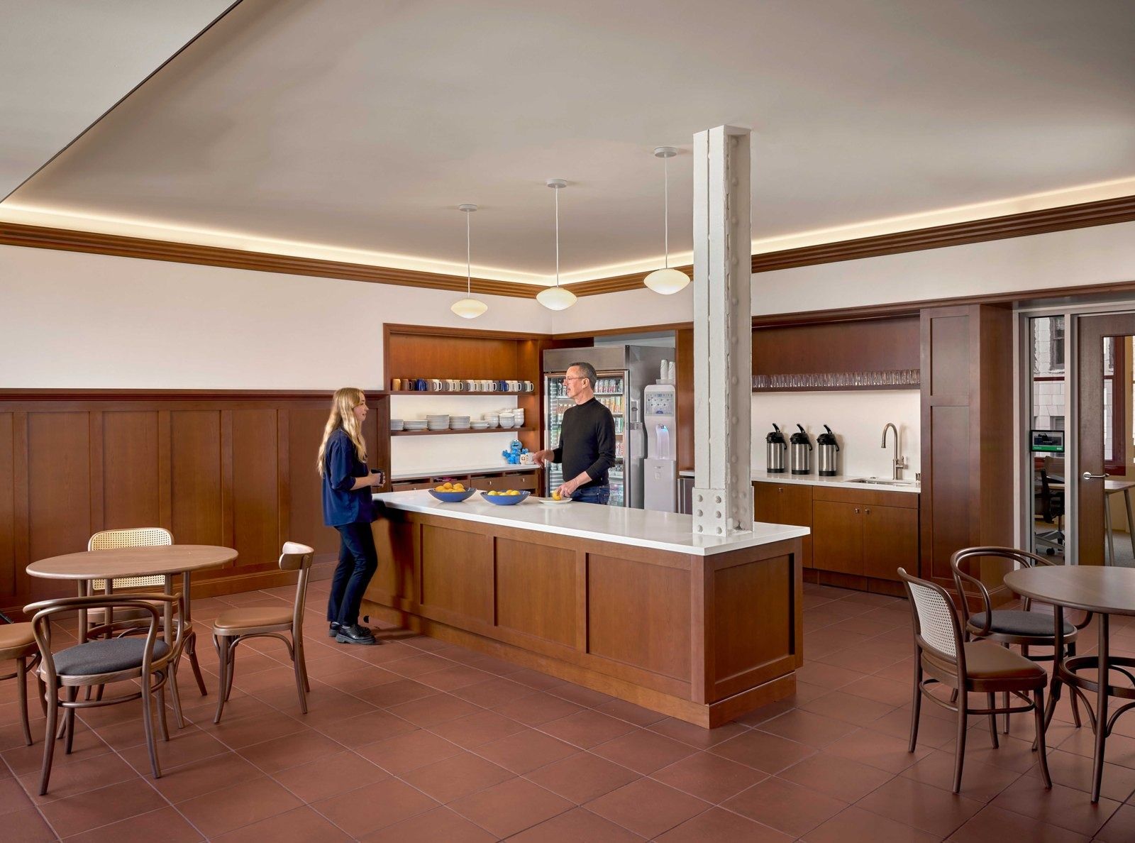 Notion: Wood-paneled counter around a riveted white steel column, with café tables and shelves of cups