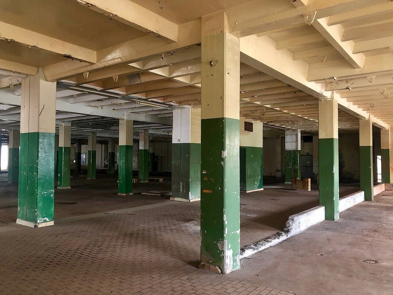 Empty factory hall with green-painted columns