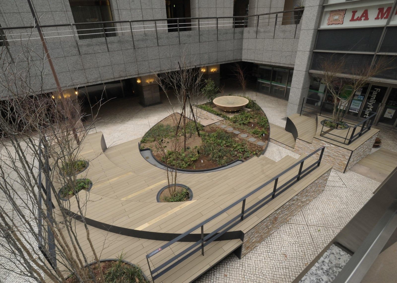 NTT: Plaza with a circular planter and trees
