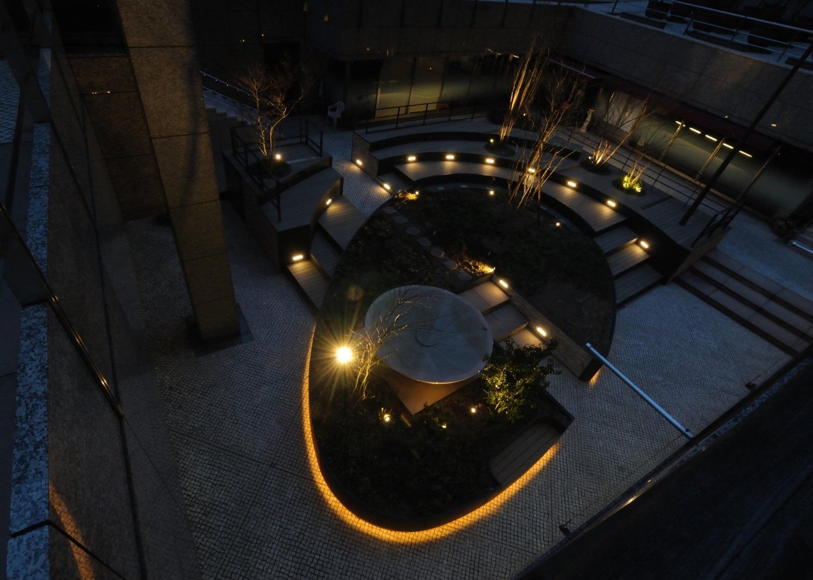 NTT: Spiral path lit at night in a sunken garden