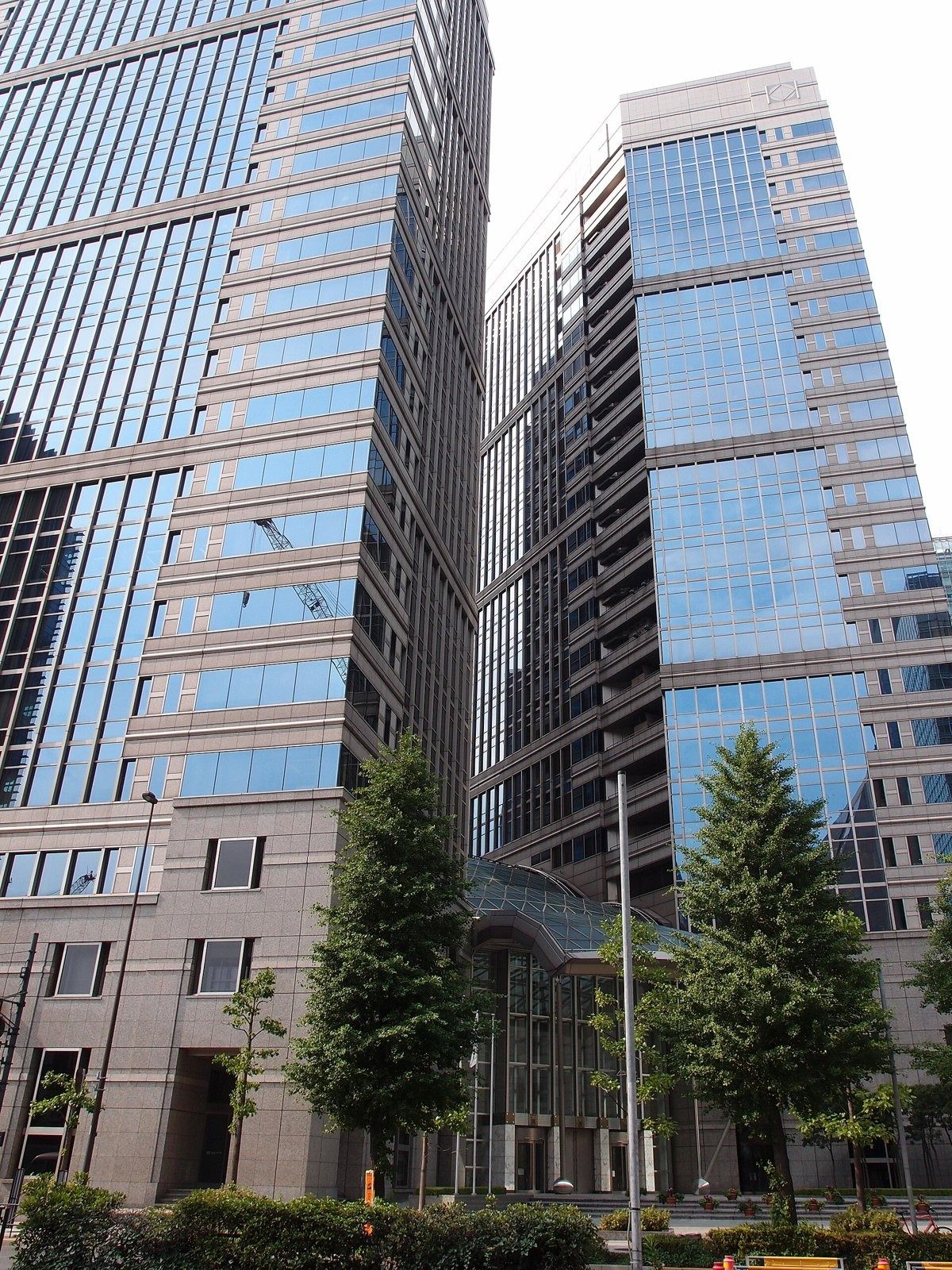 NTT: Two dark glass towers among trees