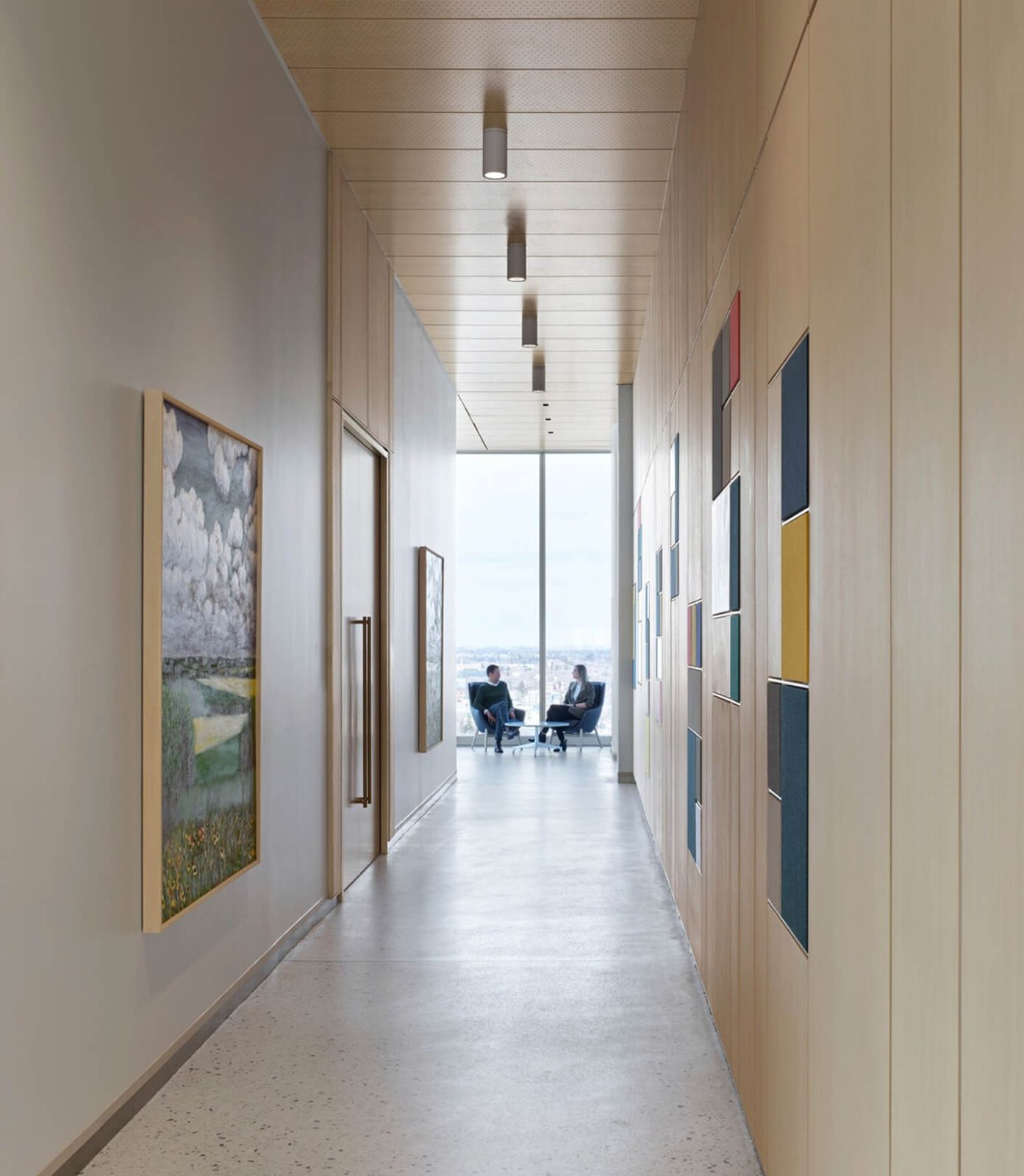 Nutrien: A long pale corridor lined with framed artworks leading to a window