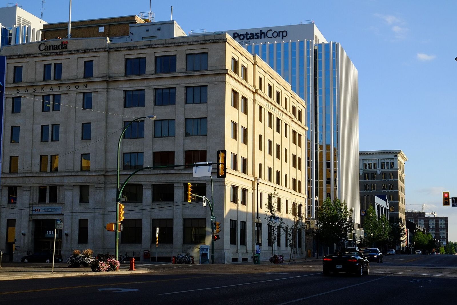 A stone office building in front of a glass tower bearing the PotashCorp name
