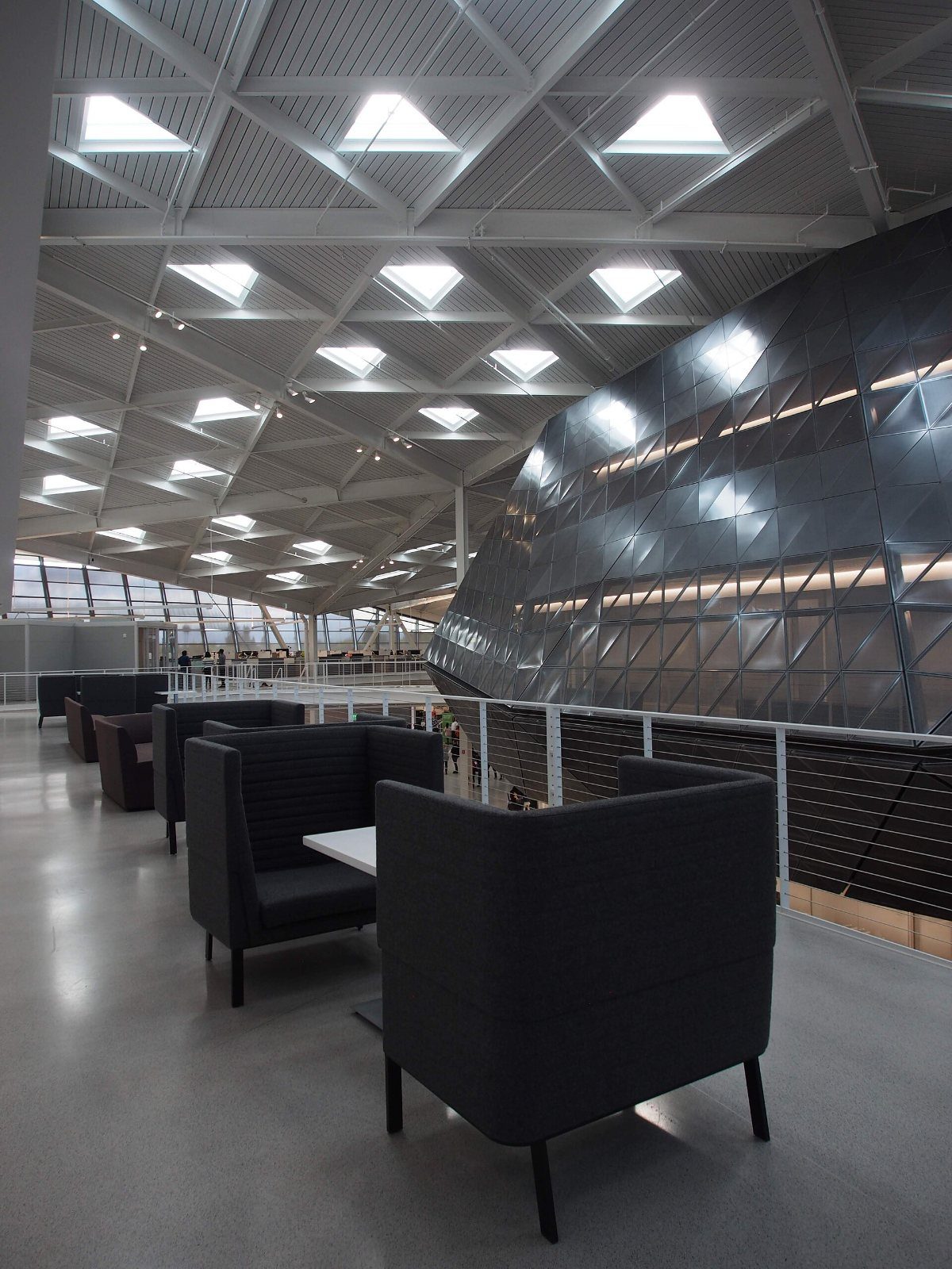 Atrium under triangular skylights with dark seating pods