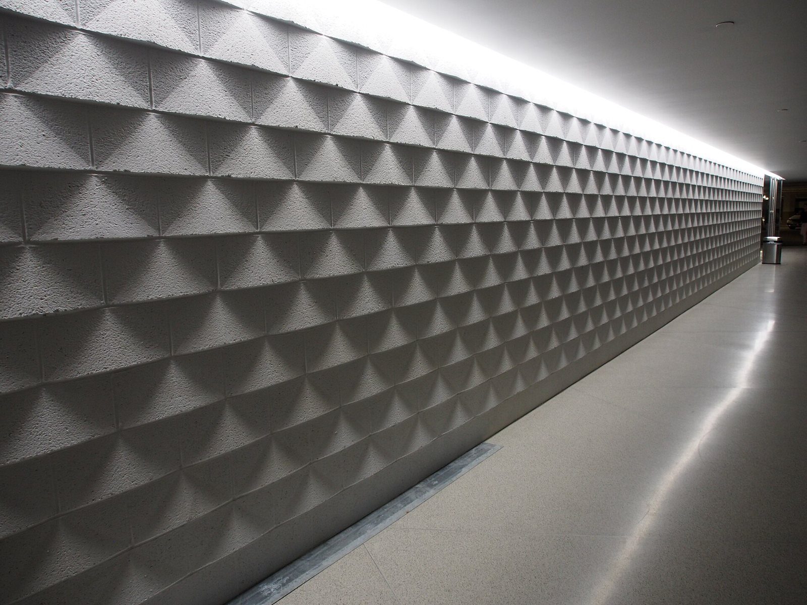 Long wall of triangular panels lit from above