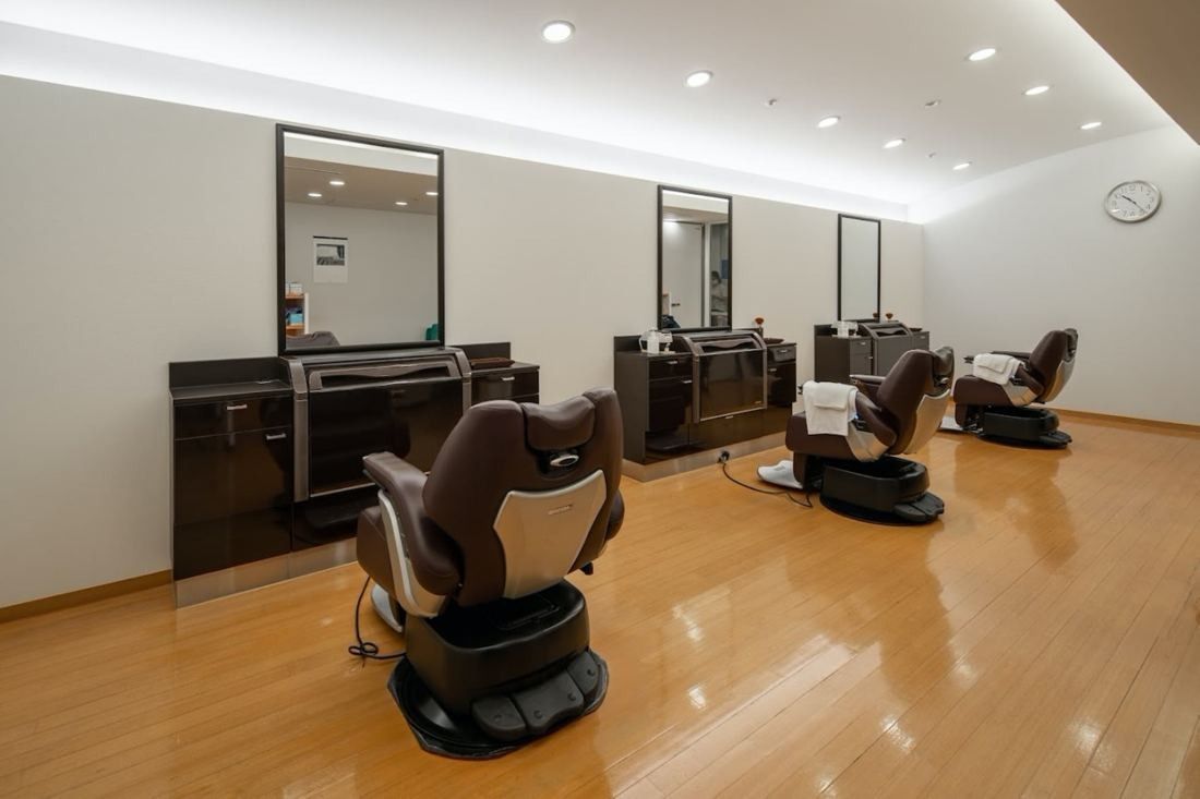 Obayashi: Barber chairs and mirrors in a bright room with wooden floor