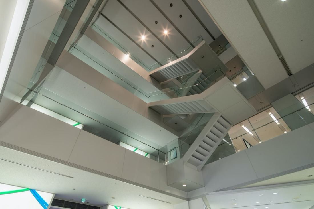 Obayashi: Looking up through an open multi-storey atrium crossed by stairs