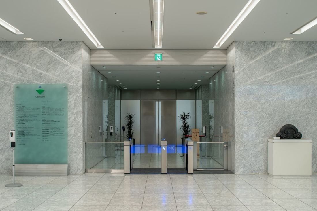 Obayashi: Marble-clad entrance hall with security gates and glass doors
