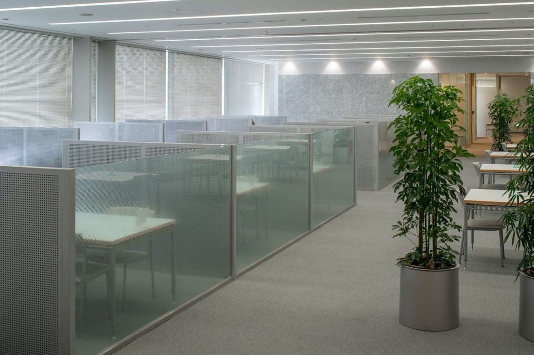 Obayashi: Row of booths with frosted glass panels and a potted plant