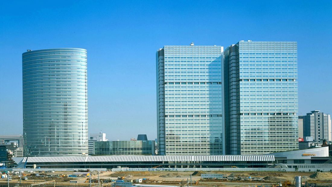Three glass office towers of a large complex against a blue sky
