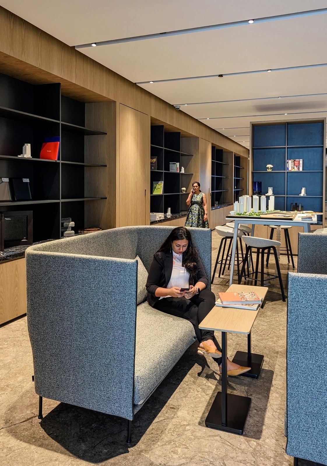 Oberoi Realty: A booth with grey upholstery by shelves