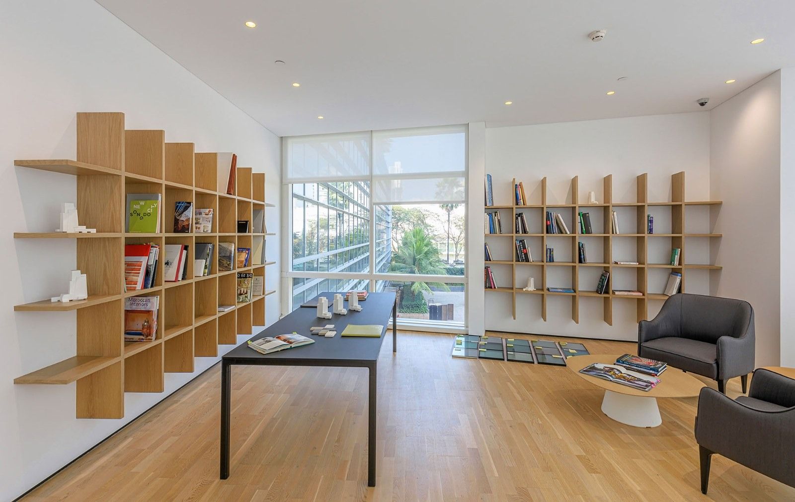 Oberoi Realty: A bright room with wooden shelving and a long table
