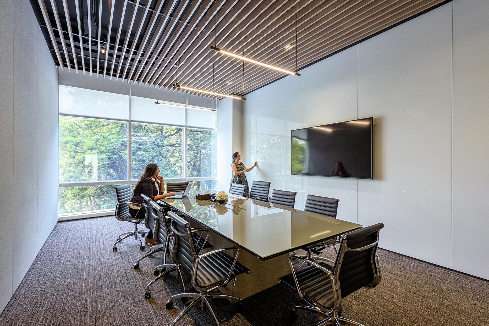 Oberoi Realty: A meeting room with a long dark table and a screen