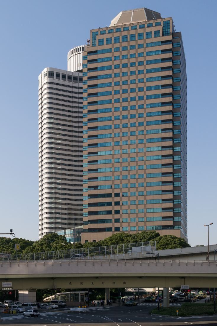 Okamura: Office tower beside a hotel tower, seen across an elevated road