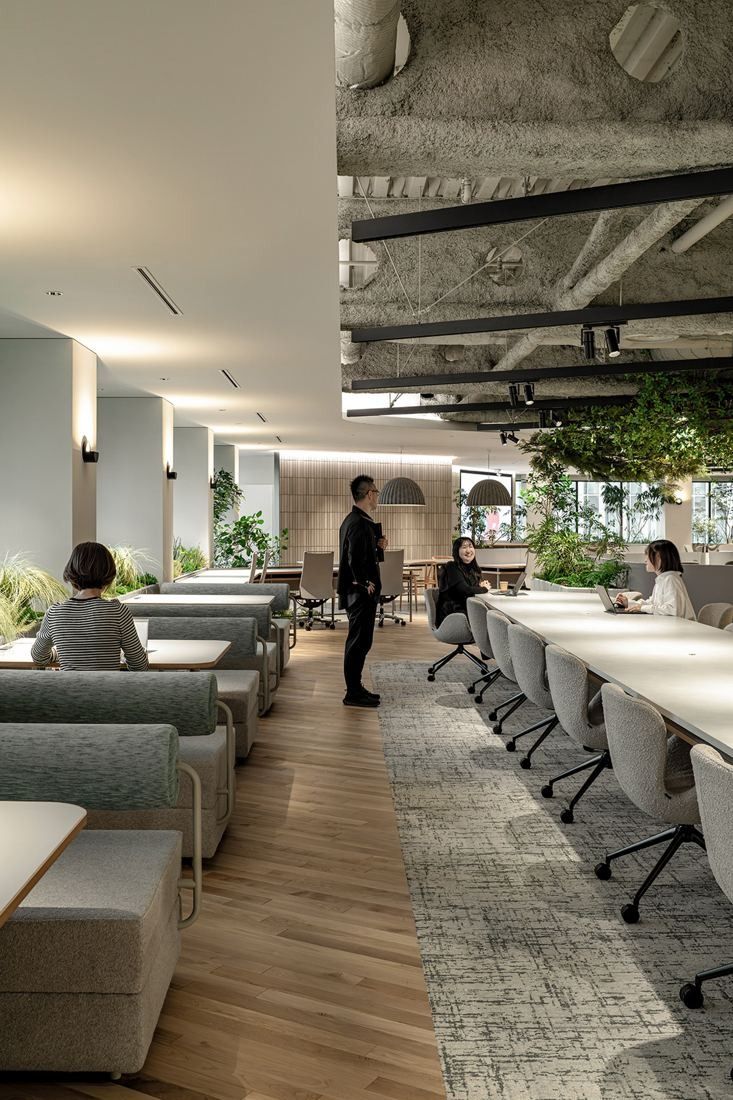 Okamura: Row of booths and desks along a corridor with an exposed ceiling