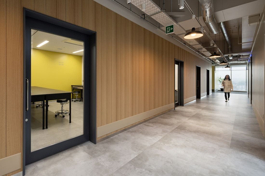 Olympus: Corridor with wood-panelled walls and a glass door into a yellow-walled room