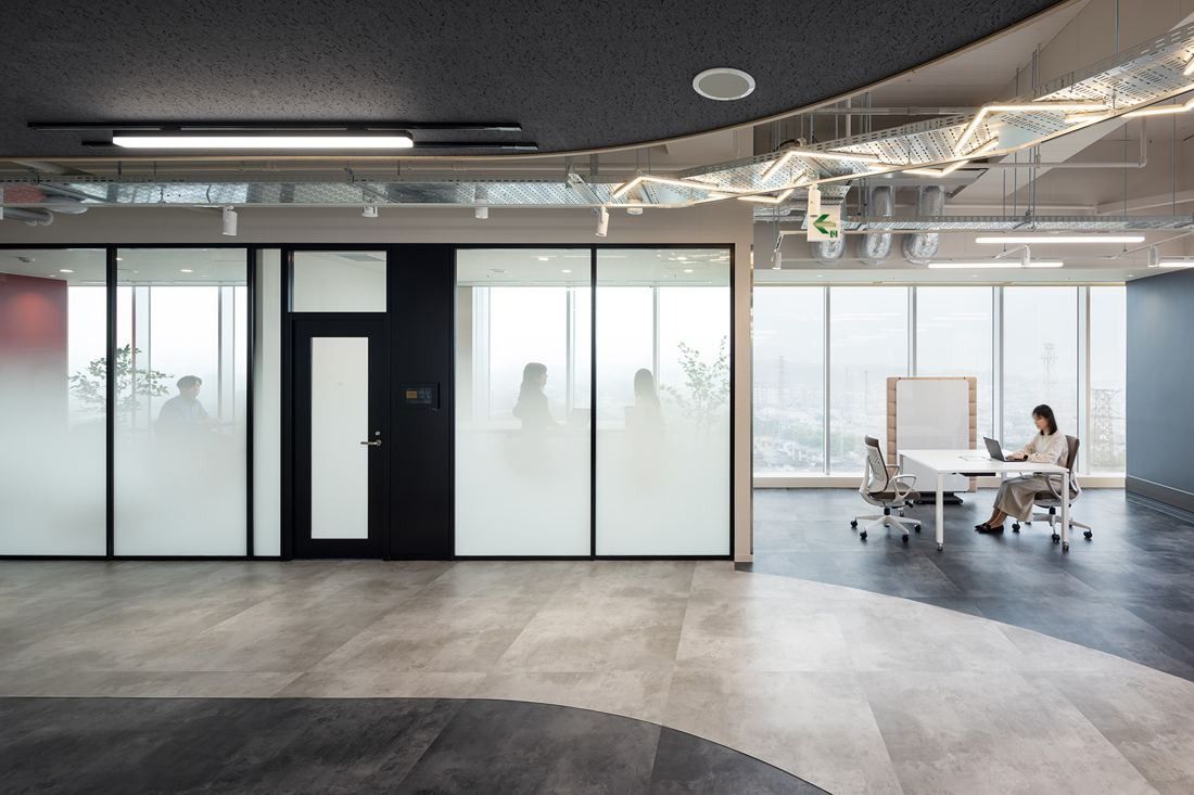 Olympus: Frosted-glass meeting rooms beside an open work area with a large window