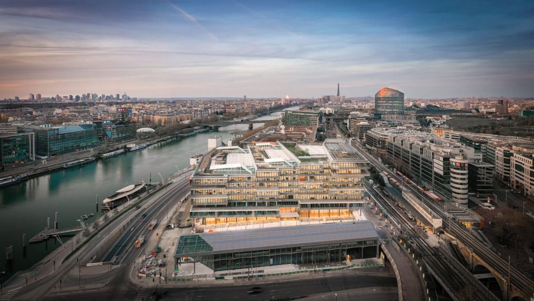 Orange: Aerial view of the building on the riverbank with the river and the city stretching into the distance
