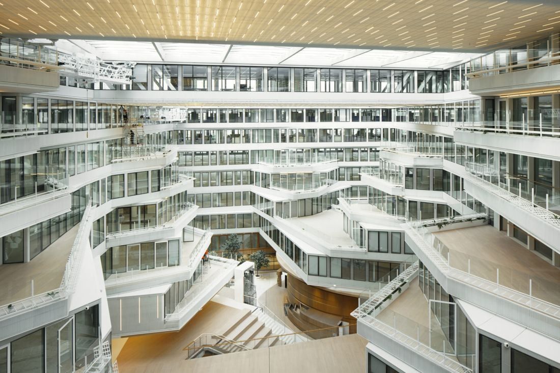 Orange: Bright atrium with white terraced floors, glass balustrades and a glass roof