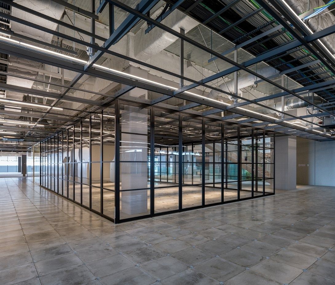 Panasonic: Empty floor with a steel grid ceiling and glass rooms