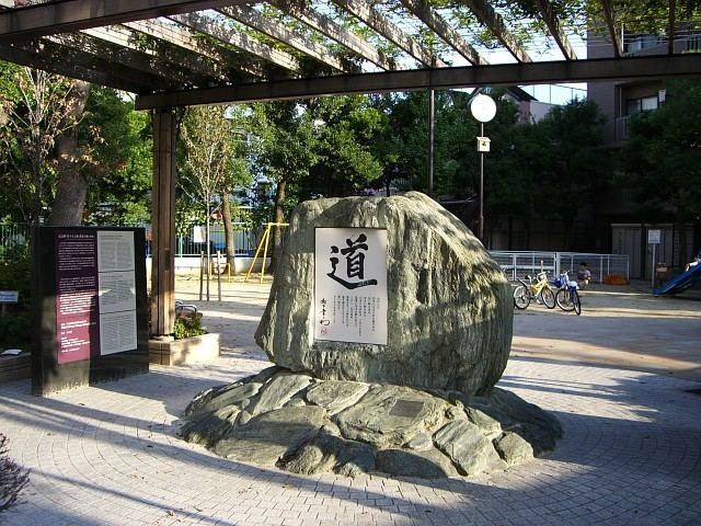 Stone monument under a pergola in a small city park