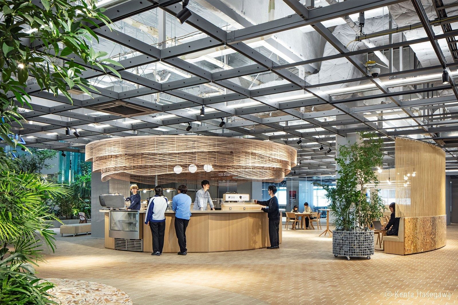 Panasonic: Round wooden kitchen counter among plants under a steel grid ceiling
